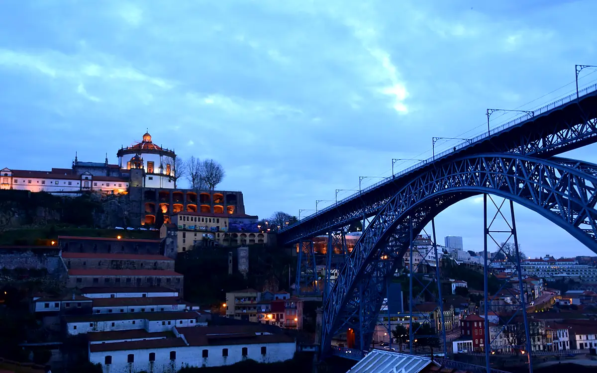 De Ponte Dom Luís I in het blauwe uur, met het verlichte klooster Serra do Pilar op de heuvel erachter