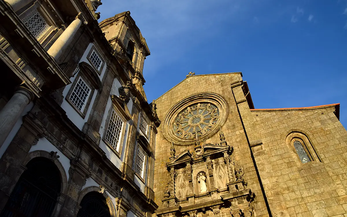 De gotische voorgevel van de Igreja de São Francisco in Porto met het rozetvenster en het gesneden portaal, naast de barokke gevel van de buurkerk