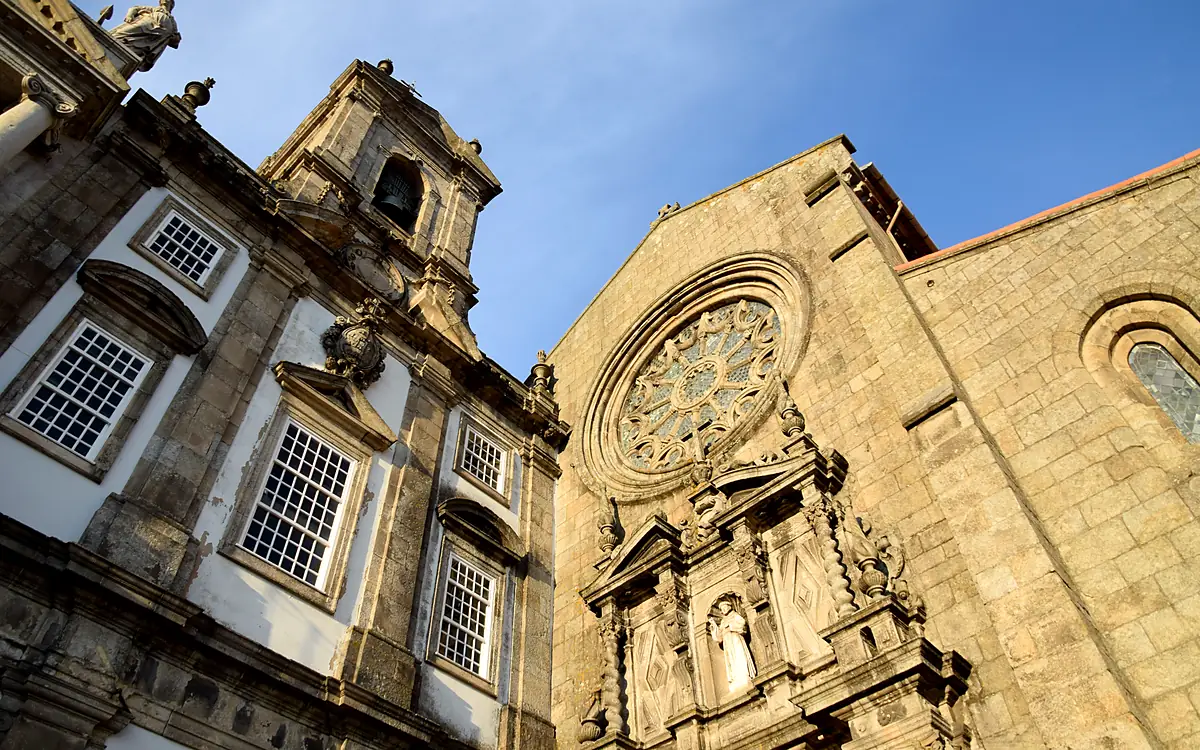 De klokkentoren naast de Igreja de São Francisco en het rozetvenster van de kerk, van onderaf tegen een blauwe lucht