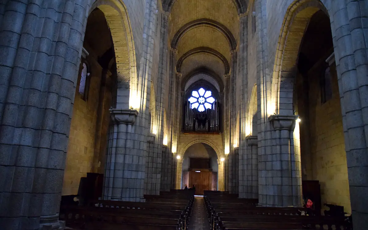 Het rozetvenster en het orgel boven de ingang van de kathedraal van Porto, gezien vanuit het middenschip tussen de zware pijlers